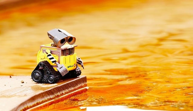 WALL-E looking at a puddle