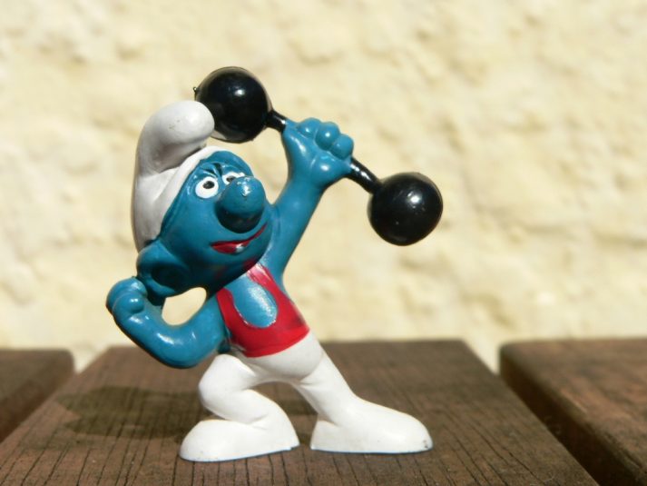 This Smurf lifts weights to grow strong.