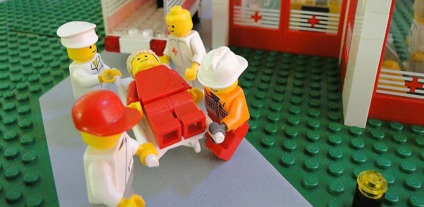 A picture of medics helping a LEGO, who is clearly very sore.