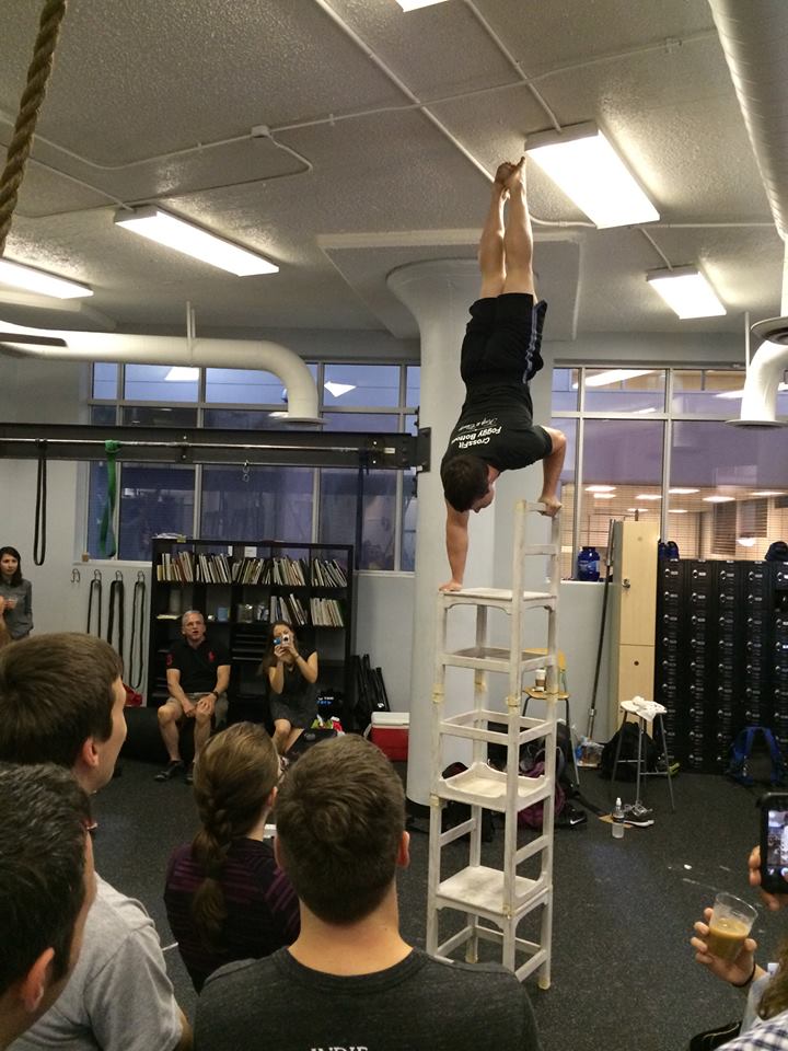 Coach Jim doing a handstand on stacked chairs. 