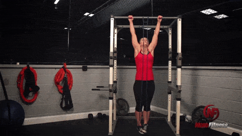 Staci using a band for an assisted pull-up, a great exercise for a bodyweight circuit.