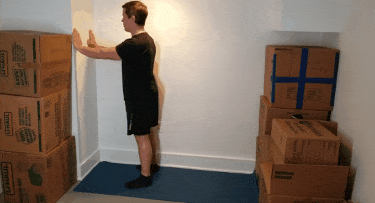 A gif of Coach Jim doing wall push-ups in a small space.
