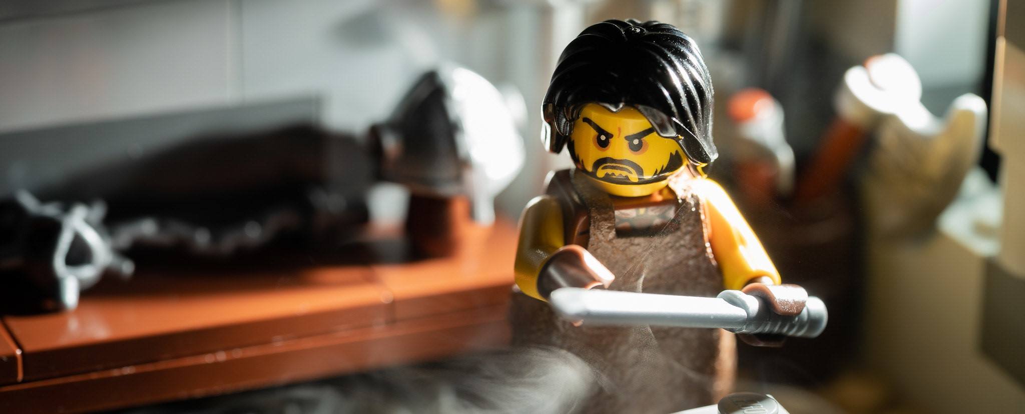 A photo of a LEGO forging his sword.